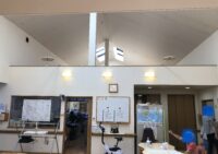 中央のリビングの写真。天井た高く開放感がある。玄関すぐに事務所があるので不用意な外出などを防止する事も可能