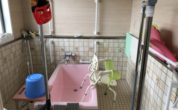 お風呂場の写真。手すりもあり、ヘルパーが必ず一緒に付くので安心。使わない時間帯は洗濯竿が置かれている