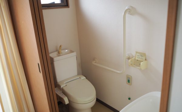 居室内のトイレは入口が広く入りやすい。ウォシュレット、手すりも付いている。