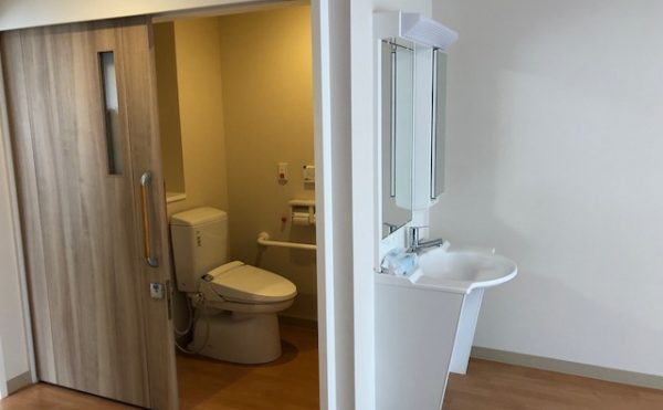 居室内トイレの写真。手すりとコールボタン完備。車椅子の方でも安心の広いスペースを確保。
