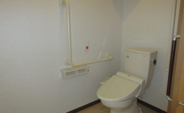 居室内トイレ。手すりとコールボタンが完備されている。車いすでも十分な広さ。